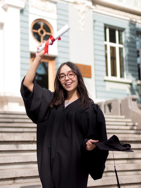 Foto gratuita joven vistiendo toga de graduación al aire libre