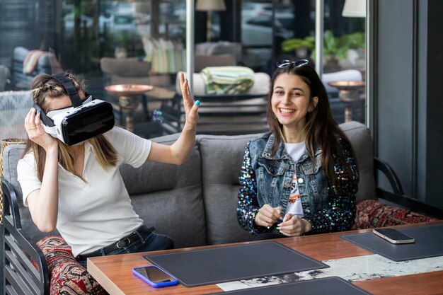 Joven vistiendo Vr set y gesto a su amiga parada