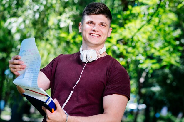 Joven volteando el cuaderno en el parque