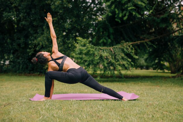 Joven yogui atractiva mujer practicando yoga en el jardín