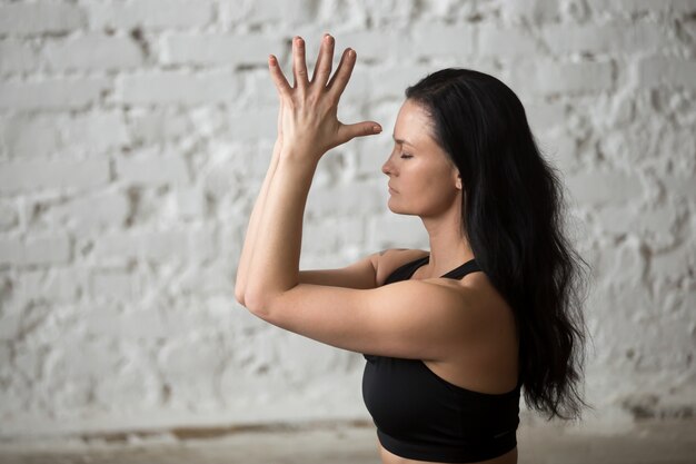 Joven, yogui, atractivo, mujer, hacer, namaste, blanco, loft, backgroun