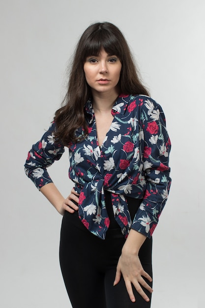 jovencita en camiseta diseñada posando con el pelo largo en blanco