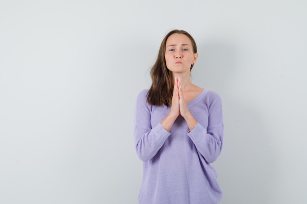 Foto gratuita jovencita cogidos de la mano en gesto de oración en camisa casual y mirando esperanzado