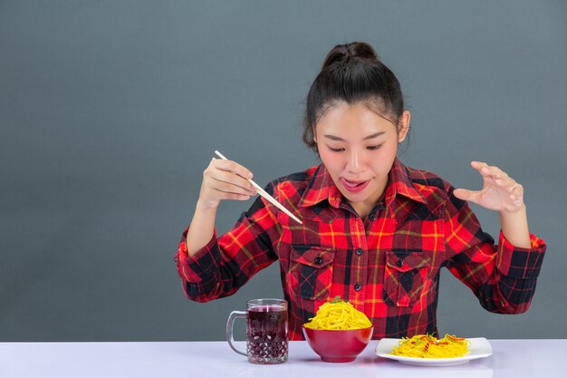 Jovencita disfruta de comer espaguetis en casa