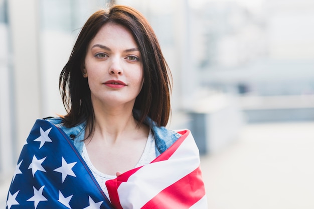 Foto gratuita jovencita enrollando en bandera americana