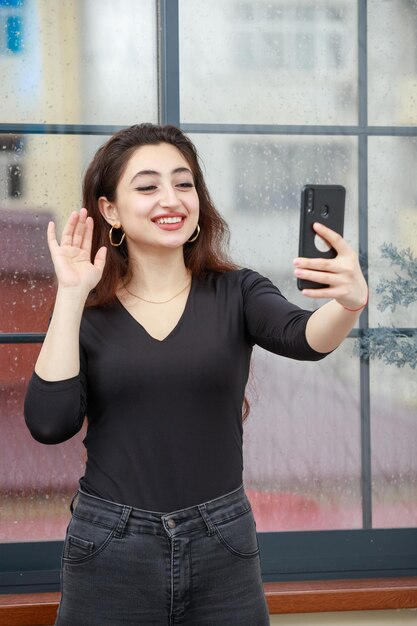 Jovencita feliz hablando por videollamada y sonriendo Foto de alta calidad