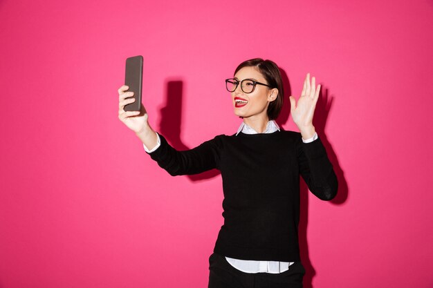 Jovencita haciendo selfie en smartphone aislado