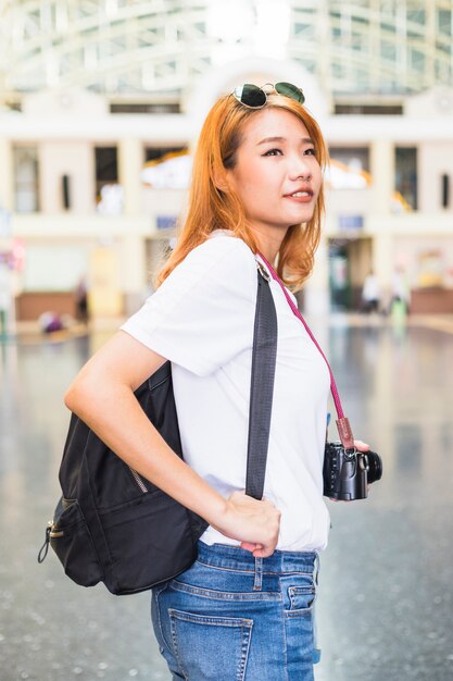 Jovencita con mochila y cámara.