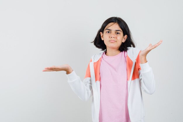 Jovencita mostrando gesto de impotencia en chaqueta, camisa rosa y mirando descontento.