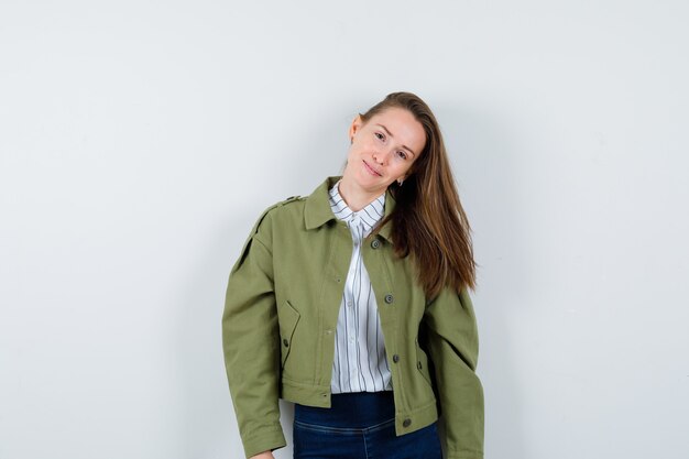 Jovencita posando mientras está de pie en camisa, chaqueta y luciendo hermosa vista frontal.