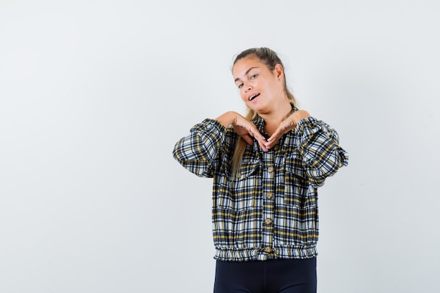 Foto gratuita jovencita posando mientras está de pie en camisa, pantalones cortos y parece cautivadora. vista frontal.