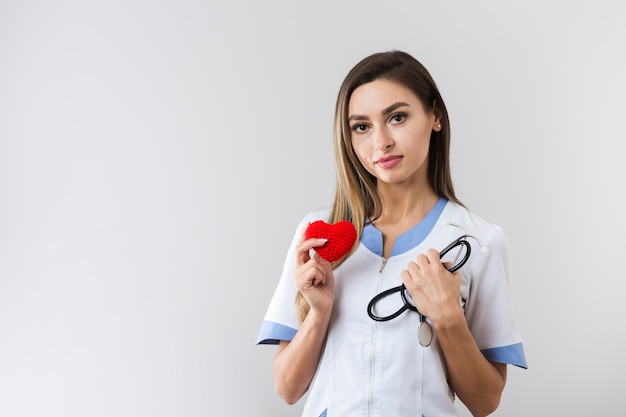 Foto gratuita jovencita sosteniendo un corazón de felpa