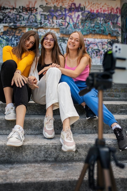 Foto gratuita jóvenes adolescentes grabando carretes de sí mismas al aire libre para las redes sociales