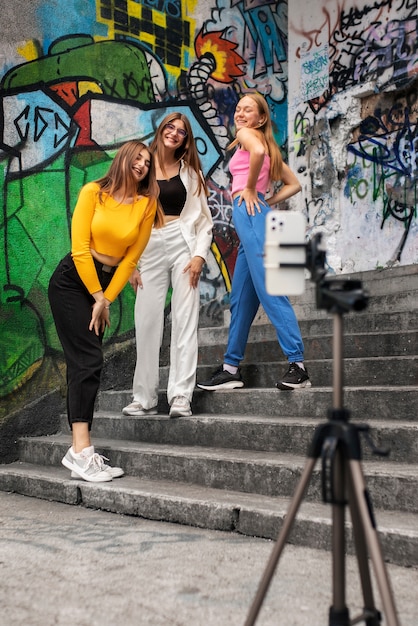 Foto gratuita jóvenes adolescentes grabando carretes de sí mismas al aire libre para las redes sociales