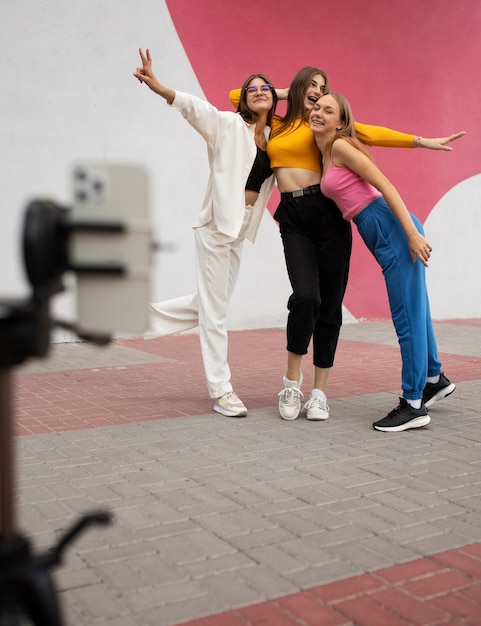 Jóvenes adolescentes grabando carretes de sí mismas al aire libre para las redes sociales