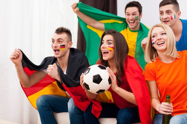 Foto gratuita jóvenes aficionados al fútbol durante el partido de visualización en la televisión