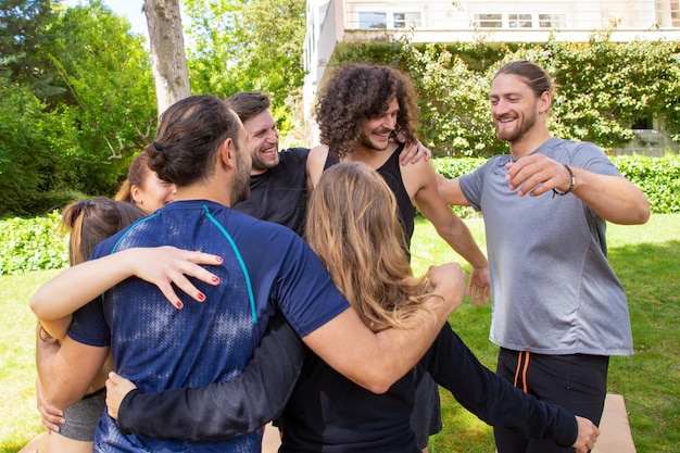 Jóvenes alegres abrazando al aire libre