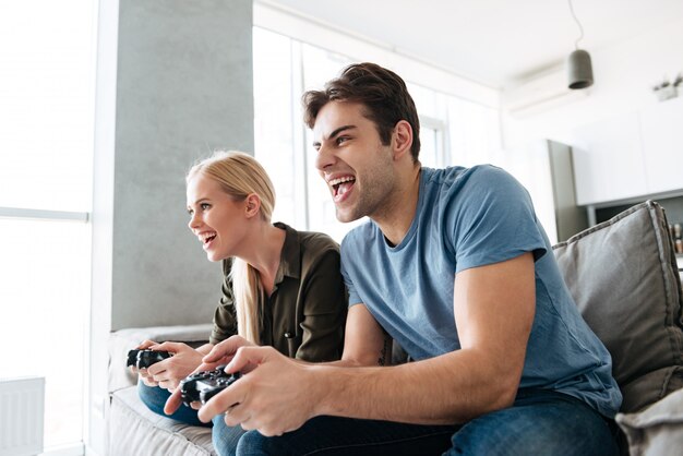 Jóvenes amantes del juego jugando videojuegos en casa