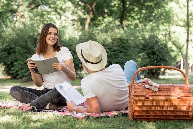 Foto gratuita jóvenes amantes leyendo en el parque