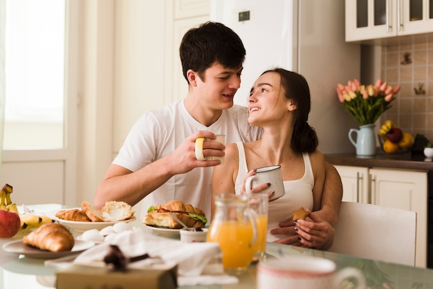 Jóvenes amantes románticos desayunando juntos