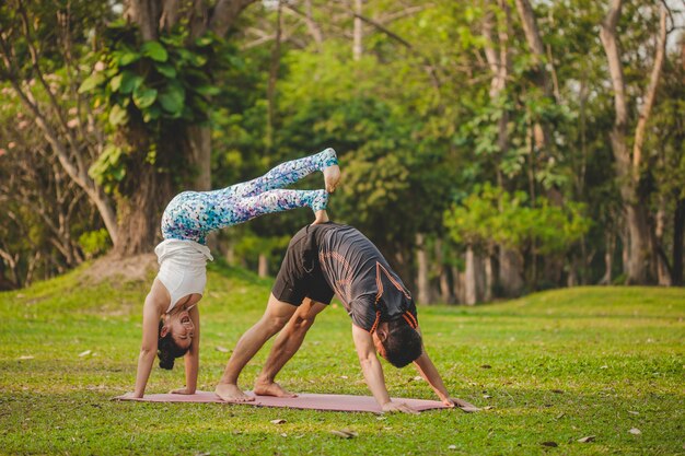 Jóvenes amantes del yoga haciendo acrobacias