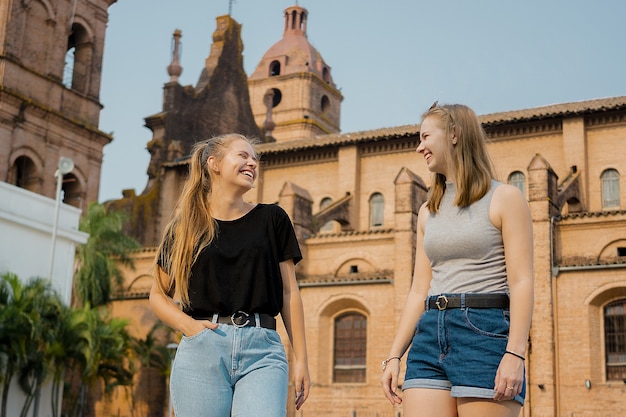 Jóvenes amigas de pie en el muro de la catedral de Santa Cruz de la Sierra