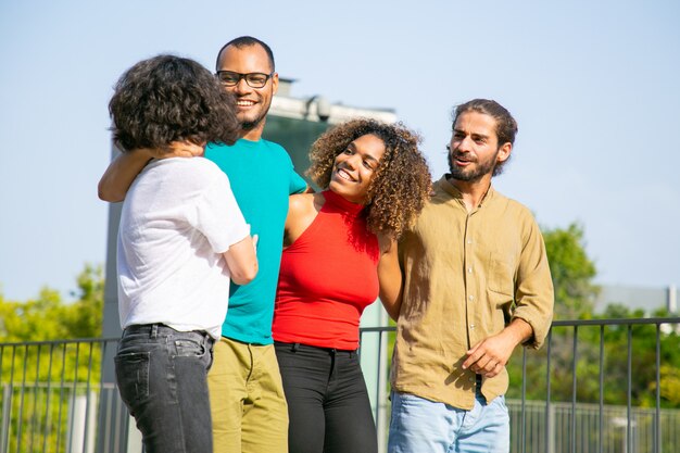 Jóvenes amigos abrazándose y caminando al aire libre