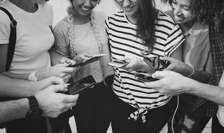 Foto gratuito jóvenes amigos adultos usando smartphones juntos al aire libre concepto de cultura juvenil