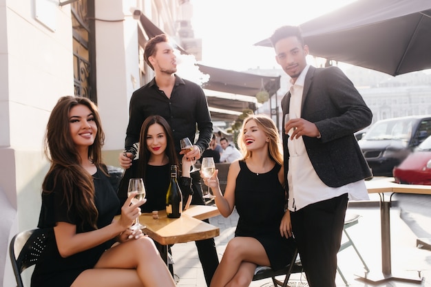 Jóvenes amigos bebiendo champán en una terraza