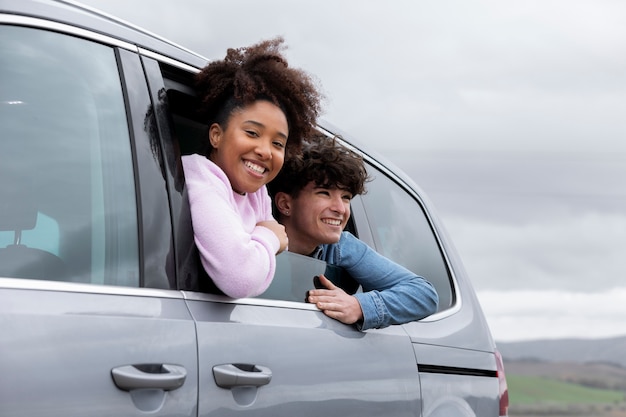 Jóvenes amigos disfrutando de un viaje familiar en coche