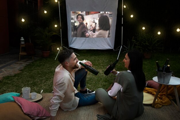 Jóvenes amigos divirtiéndose en el cine al aire libre