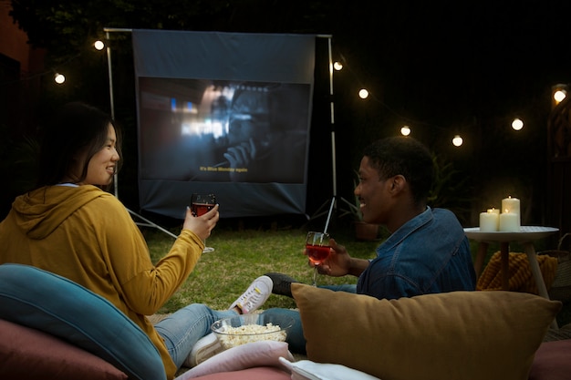 Jóvenes amigos divirtiéndose en el cine al aire libre