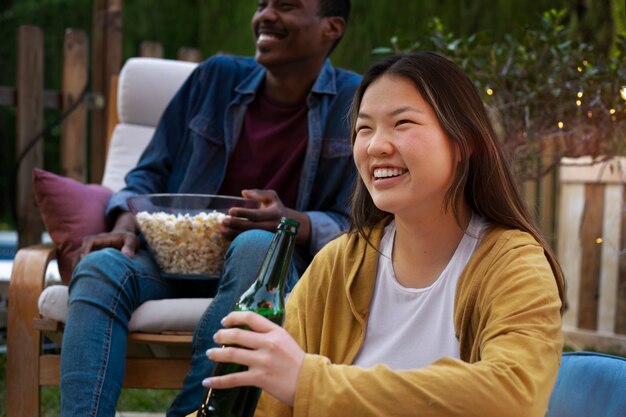 Jóvenes amigos divirtiéndose en el cine al aire libre