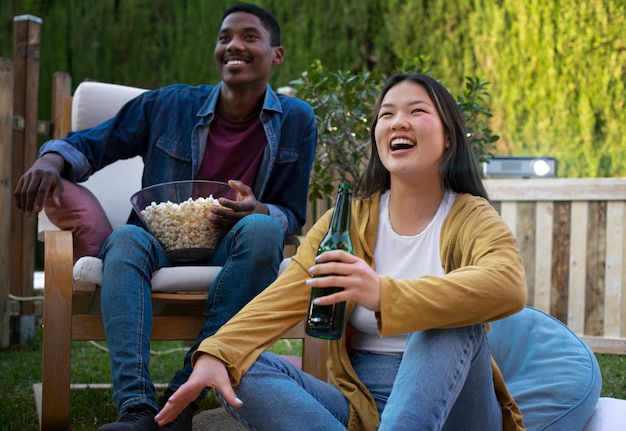 Jóvenes amigos divirtiéndose en el cine al aire libre