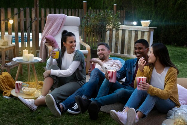 Jóvenes amigos divirtiéndose en el cine al aire libre