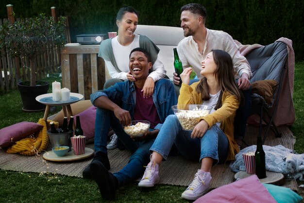 Jóvenes amigos divirtiéndose en el cine al aire libre