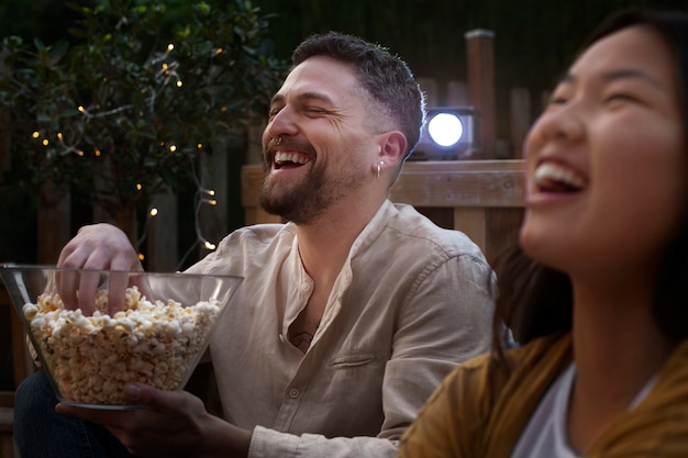 Jóvenes amigos divirtiéndose en el cine al aire libre