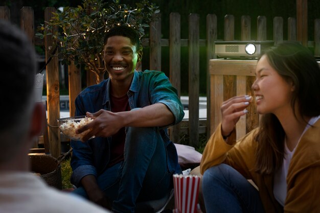 Jóvenes amigos divirtiéndose en el cine al aire libre