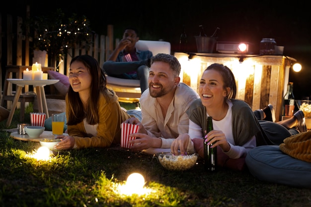 Jóvenes amigos divirtiéndose en el cine al aire libre