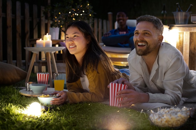 Jóvenes amigos divirtiéndose en el cine al aire libre