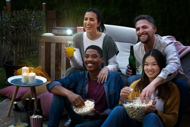 Jóvenes amigos divirtiéndose en el cine al aire libre