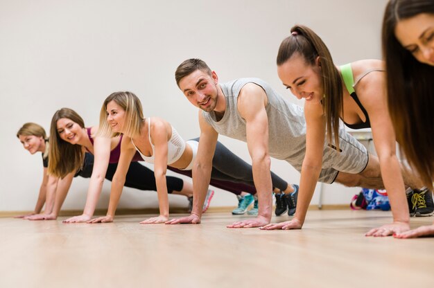 Jóvenes amigos entrenando juntos en el gimnasio