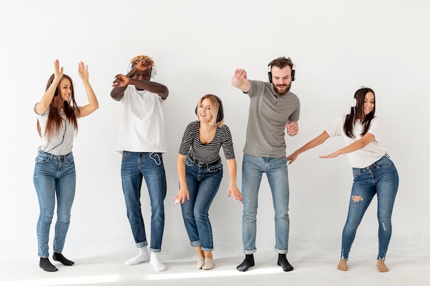 Jóvenes amigos escuchando música y bailando