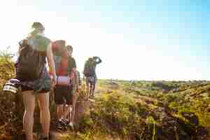 Foto gratuita jóvenes amigos hermosos viajeros con mochilas caminando en el cañón