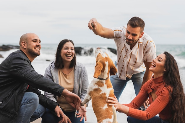 Jóvenes amigos jugando con perro