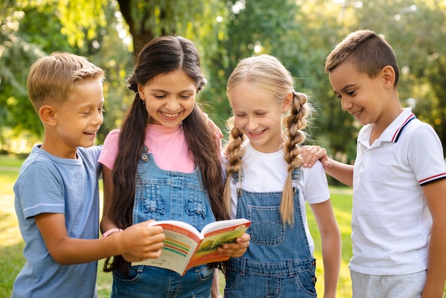 Jóvenes amigos leyendo libro juntos