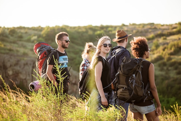 Jóvenes amigos con mochilas disfrutando de la vista, viajando en el cañón