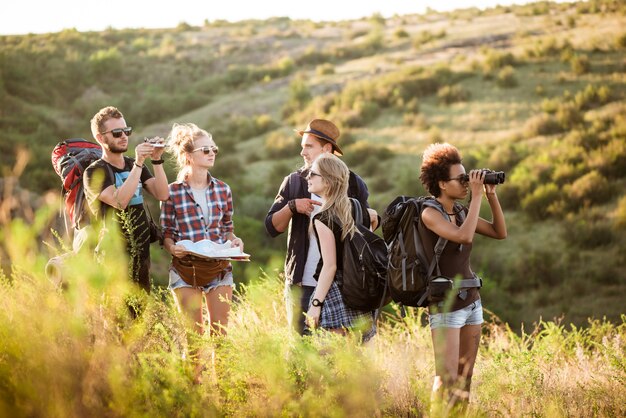 Jóvenes amigos con mochilas disfrutando de la vista, viajando en el cañón