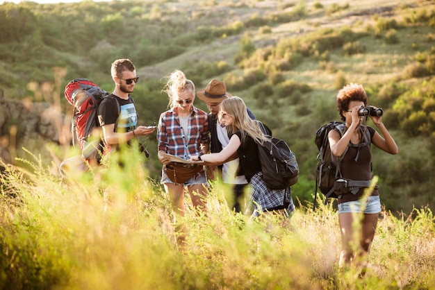 Jóvenes amigos con mochilas disfrutando de la vista, viajando en el cañón