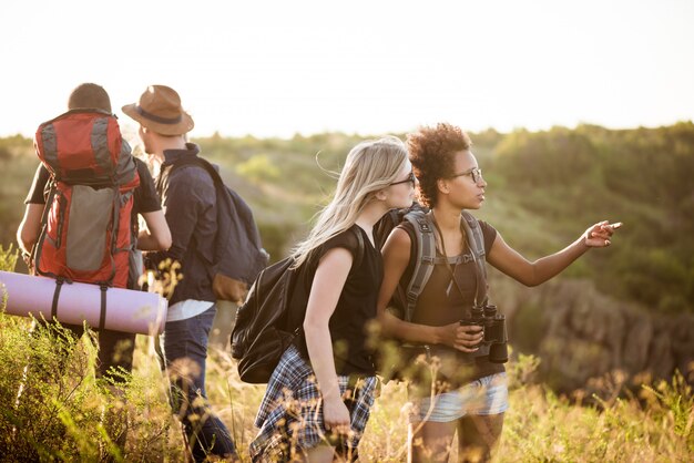 Jóvenes amigos con mochilas disfrutando de la vista, viajando en el cañón